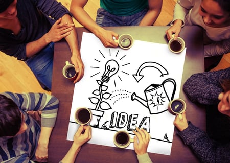 Composite image of idea and innovation graphic on page with people sitting around table drinking coffee-1